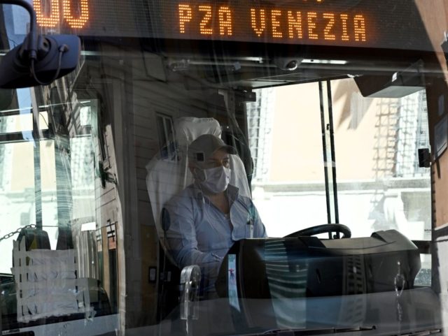 A driver wearing a protection steers a public transport bus on Via del Corso in central Ro