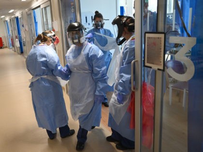 CAMBRIDGE, UNITED KINGDOM - MAY 05: Clinical staff wear Personal Protective Equipment (PPE) as they care for a patient at the Intensive Care unit at Royal Papworth Hospital on May 5, 2020 in Cambridge, England. NHS staff wear an enhanced level of PPE in higher risk areas such as critical …