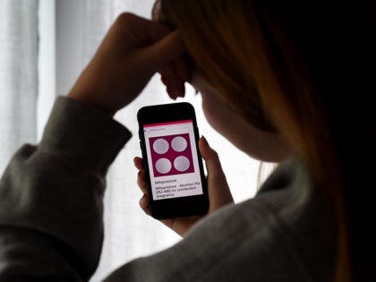 In this photo illustration, a person looks at an Abortion Pill (RU-486) for unintended pregnancy from Mifepristone displayed on a smartphone on May 8, 2020, in Arlington, Virginia. - One week after Sally realized she was pregnant, her home state Texas temporarily banned abortions, deeming them unnecessary elective procedures that …