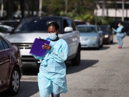 WEST PALM BEACH, FLORIDA - MARCH 16: Health care staff from the FoundCare center wear protective gear as they help people who called to setup a drive through appointments to be tested for the coronavirus in the centers parking lot on March 16, 2020 in West Palm Beach, Florida. FoundCare, …