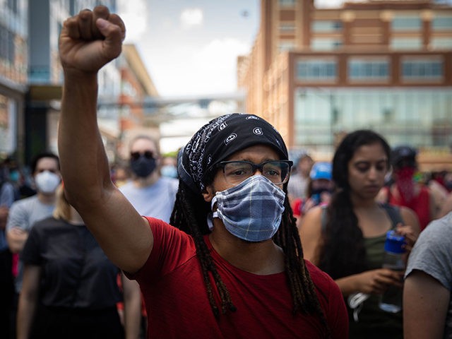 A protester raises a first during a demonstration against racism and police brutality in P