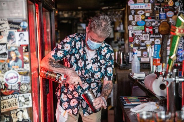A bartender wearing a facemask makes a drink at a restaurant in Austin, Texas, June 26, 2020. - Texas Governor Greg Abbott ordered bars to be closed by noon on June 26 and for restaurants to be reduced to 50% occupancy. Coronavirus cases in Texas have spiked in recent weeks …