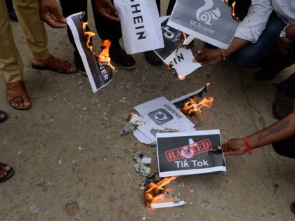 Members of the City Youth Organisation burn posters with the logos of Chinese apps in support of the Indian government for banning the wildly popular video-sharing 'Tik Tok' app, in Hyderabad on June 30, 2020. - TikTok on June 30 denied sharing information on Indian users with the Chinese government, …
