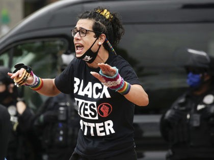 A protester in a Black Lives Matter shirt stands outside the Capitol Hill Occupied Protest (CHOP) after police cleared it and retook the department's East Precinct in Seattle, Washington on July 1, 2020. (Photo by Jason Redmond / AFP) (Photo by JASON REDMOND/AFP via Getty Images)