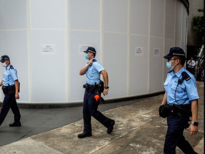 Police walk past windows that have been covered up at the Metro Park hotel in Causeway Bay on July 7, 2020, the hotel which is being retrofitted and turned into office for safeguarding national security of the peoples republic of China in the Hong Kong special administrative region. - China …