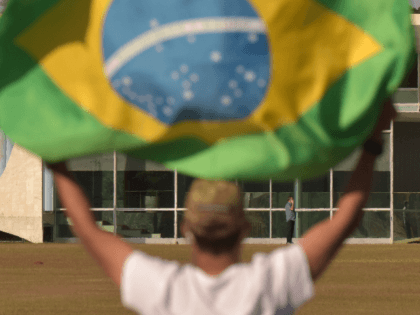 Supporter of Brazilian President Jair Bolsonaro waves him at the door of official residenc