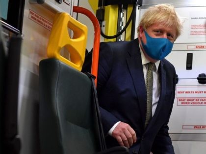 Britain's Prime Minister Boris Johnson, wearing a face mask or covering due to the COVID-19 pandemic, boards an ambulance to talk with a paramedic, during his visit to the headquarters of the London Ambulance Service NHS Trust in central London on July 13, 2020. (Photo by Ben STANSALL / various …