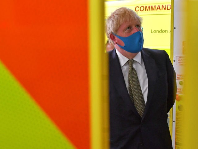 LONDON, UNITED KINGDOM - JULY 13: Britain's Prime Minister Boris Johnson, wearing a face mask or covering due to the COVID-19 pandemic, talks with a paramedic standing in side an ambulance, during his visit to the headquarters of the London Ambulance Service NHS Trust on July 13, 2020 in London, …