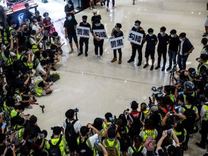 District councillors (top) protest inside at a mall at Yuen Long in Hong Kong on July 19,