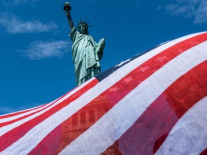 NEW YORK, NY - JULY 20: The Statue of Liberty is seen over a wind blown American flag scarf on Liberty Island on July 20, 2020 in New York City. Liberty Island partially reopens months after the attraction was shut down due to the coronavirus pandemic. Access to Liberty Island …