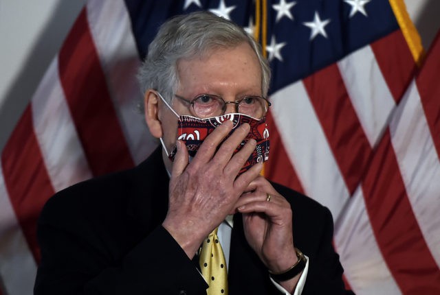 US Senate Majority Leader Mitch McConnell, adjusts his mask after a Republican policy lunc