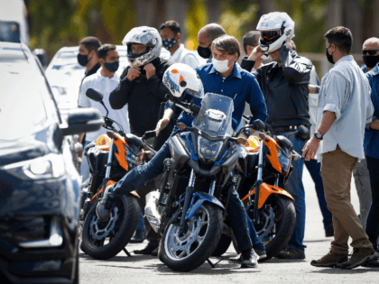 Brazilian President Jair Bolsonaro (C) takes a ride and has his motorcycle's engine overha
