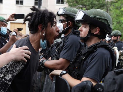 WASHINGTON, DC - JUNE 03: A demonstrator shouts a law enforcement officer during a peaceful protest against police brutality and the death of George Floyd, on June 3, 2020 in Washington, DC. Protests in cities throughout the country have been been held after the death of George Floyd, a black …