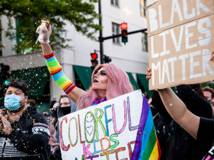 A drag queen throws glitter during a march in support of Black Lives Matter and Black Tran