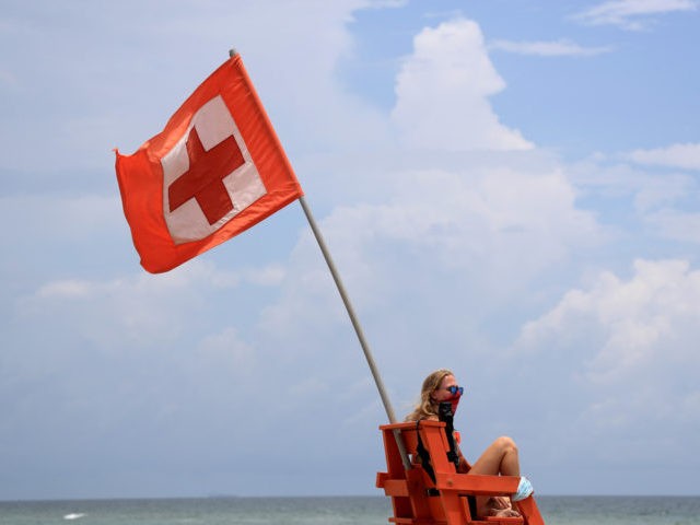 JACKSONVILLE BEACH - JULY 04: A lifeguard watches swimmers on July 04, 2020 in Jacksonville Beach, Florida. Jacksonville Beach Mayor Charlie Latham said that Duval County beaches will remain open over the 4th of July holiday, but it will be virtually impossible for the city to enforce social distancing. (Photo …