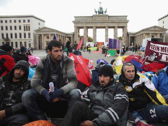 BERLIN, GERMANY - OCTOBER 17: Refugees from Iraq, Iran and Afghanistan keep warm on the 8t