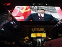 TOPSHOT - People walk outside a shop below a screen showing news coverage about Chinese President Xi Jinping, in Beijing on October 25, 2017. Chinese President Xi Jinping was formally handed a second term on October 25, 2017, with no clear successor emerging in a revamped ruling council, cementing his …