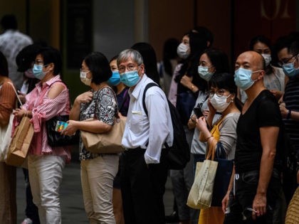 Pedestrians wear face masks as they wait to cross a road in Hong Kong on July 10, 2020, as the city experiences new local outbreaks of the COVID-19 coronavirus. - The finance hub recorded 38 new confirmed cases on July 10, thirty-two of which were locally transmitted. (Photo by Anthony …