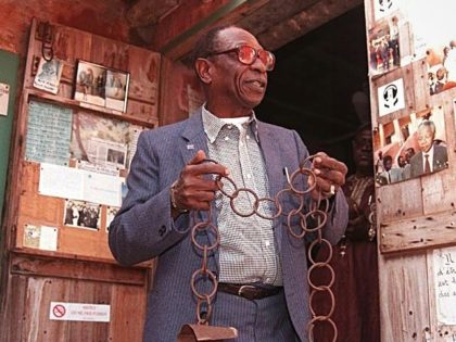 DAKAR, SENEGAL: Joe N'Diaye, director of the House of Slaves on Goree Island, near Dakar, poses for the photographer 26 April with some chains formerly used for slaves. France prepares to commemorate the 150th anniversary of the abolition of slavery in the French colonies. The site, which was the point …