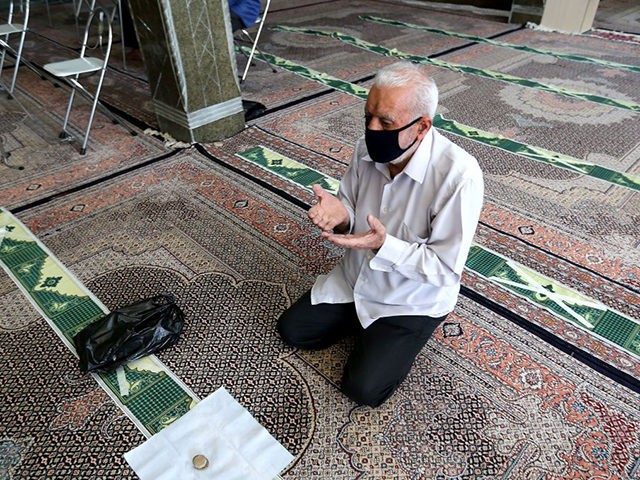 A mask-clad Iranian man prays at a mosque in the capital Tehran, amid the ongoing novel co