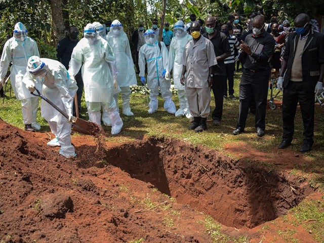 Members of Bungoma County Isolation Team in personal protection equipment (PPE) bury the c