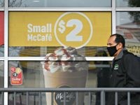 A man wears a mask as he walks past a McDonald's fast food restaurant during the COVID-19 pandemic, in Los Angeles, California, April 6, 2020. (Photo by Robyn Beck / AFP) (Photo by ROBYN BECK/AFP via Getty Images)