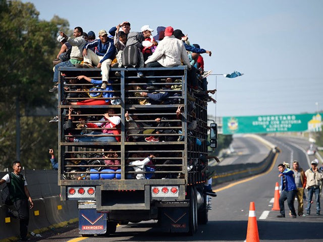 Central American migrants -mostly honduran- taking part in a caravan to the US, are pictured on board a truck heading to Irapuato in the state of Guanajuato on November 11, 2018 after spending the night in Queretaro in central Mexico. - The United States embarked Friday on a policy of …