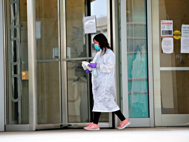 women cleans the entrance doors to Moderna headquarters in Cambridge, Massachusetts on May 18, 2020. - US biotech firm Moderna reported promising early results from the first clinical tests of an experimental vaccine against the novel coronavirus performed on a small number of volunteers. The Cambridge, Massachusetts-based company said the …