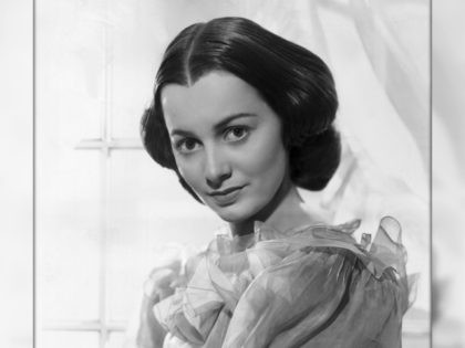 circa 1939: Promotional studio portrait of American actor Olivia de Havilland, standing in