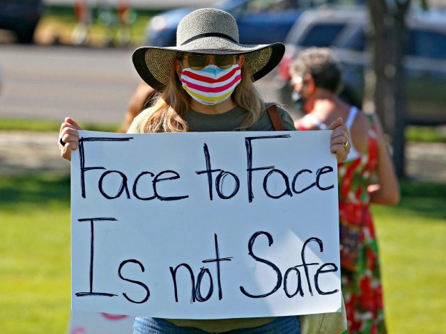 Kris Reddout, a 5th grade teacher, attends a Utah Safe Schools Mask-In urging the governor's leadership in school reopening during a rally Thursday, July 23, 2020, in Salt Lake City. Parents and teachers rallied at the Utah State Capitol Thursday morning to urge schools to enforce mask wearing and to …