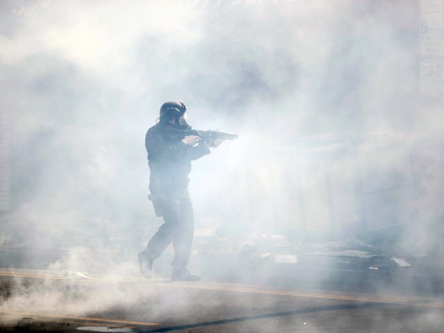 A police officer moves through tear gas deployed to disperse a crowd as Justice for George Floyd Philadelphia Protests continue Sunday, May 31, 2020, in Philadelphia. Protests were held throughout the country over the death of Floyd, a black man who died after being restrained by Minneapolis police officers on …