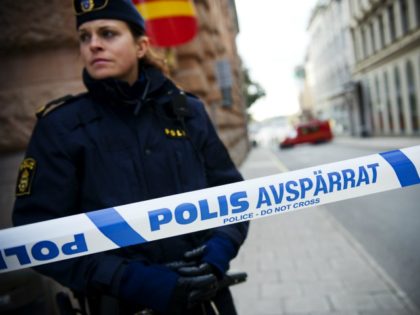 A police officer stands guard as a police and fire department team inspects a street and building where a suspicious package was found, next to the Rosenbad government office, in Stockholm, on October 13, 2011. Police said they had evacuated parts of Sweden's government building, which houses Prime Minister Fredrik …