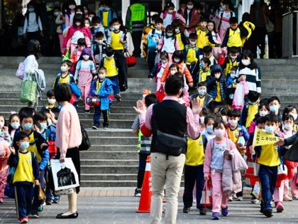 Children wearing face masks leave their elementary school at the end of the day in Xindian