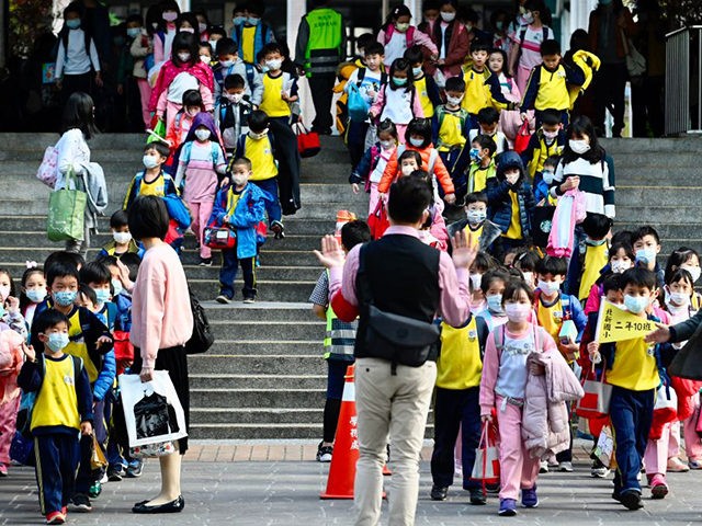 Children wearing face masks leave their elementary school at the end of the day in Xindian