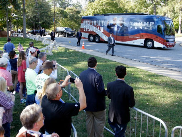 Supporters take photos as a bus carrying Republican vice presidential candidate, Indiana G