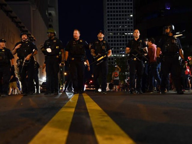 Police officers march towards the crowd where Trump supporters and anti-Trump protestors now roam the same area in Tulsa, Oklahoma where Donald Trump held a campaign rally earlier on June 20, 2020. - Hundreds of supporters lined up early for Donald Trump's first political rally in months, saying the risk …