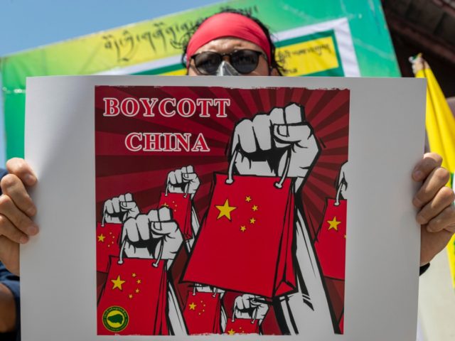 An exile Tibetan activist holds a banner during a street demonstration by the Tibetan Youth Congress asking for a boycott of Chinese goods in Dharmsala, India, Tuesday, June 16, 2020. (AP Photo/Ashwini Bhatia)
