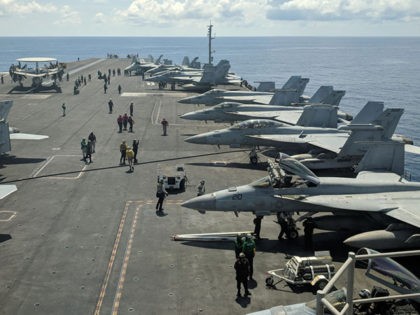 This photograph taken on October 16, 2019 shows US Navy F/A-18 Super Hornets multirole fighters and an EA-18G Growler electronic warfare aircraft (2nd R) on board USS Ronald Reagan (CVN-76) aircraft carrier as it sails in South China Sea on its way to Singapore. (Photo by Catherine LAI / AFP) …