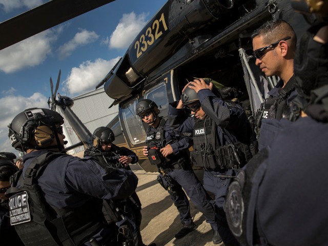 Members of the U.S. Customs and Border Protection, Office of Field Operations Special Response Team, gather outside an AMO UH-60 Black Hawk helicopter after an air-intercept training exercise as they provide airspace security for Super Bowl LI, in Conroe, Texas, Feb. 1, 2017. Units with Air and Marine Operations and …