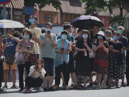 People stand on a road leading to the US Consulate in Chengdu, southwestern China's Sichuan province on July 27, 2020. - The American flag was lowered at the United States consulate in Chengdu, days after Beijing ordered it to close in retaliation for the shuttering of the Chinese consulate in …