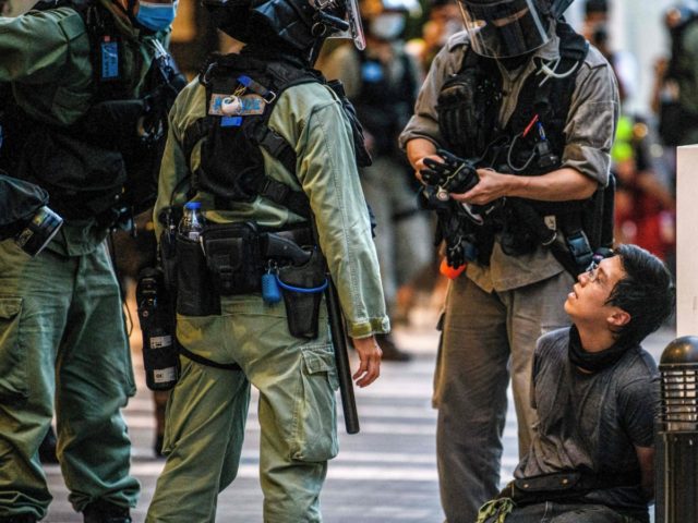 A protester (centre R) is detained by police during a rally against a new national securit