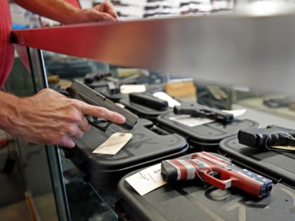A worker restocks handguns at Davidson Defense in Orem, Utah on March 20, 2020. - Gun stores in the US are reporting a surge in sales of firearms as coronavirus fears trigger personal safety concerns. (Photo by GEORGE FREY / AFP) (Photo by GEORGE FREY/AFP via Getty Images)