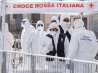 Italian police attend migrants rescued in the Mediterranean as they disembark from the Sea Watch NGO's ship on February 27, 2020 in the port of Messina, Sicily. - Migrants are checked for COVID-19 as they disembark from the NGO Sea Watch in the port of Messina. (Photo by Giovanni ISOLINO …