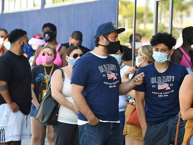 People wearing face masks wait in line to shop at Ikea in Carson, California on July 4, 20