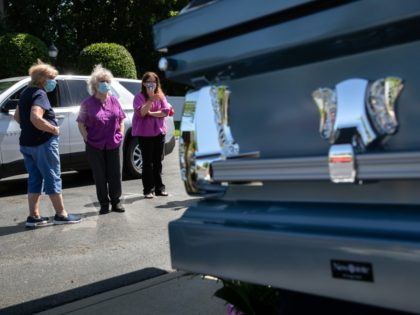 FREEHOLD, NEW JERSEY - JUNE 09: People view the coffin of Lieselotte Tonon, 85, outside the Clayton and McGirr Funeral Home during a drive-by viewing on June 09, 2020 in Freehold, New Jersey. The funeral home began offering outdoor drive-by services to families to help larger numbers of people pay …