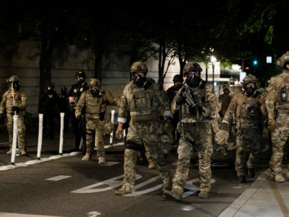 Federal officers prepare to disperse the crowd of protestors outside the Multnomah County