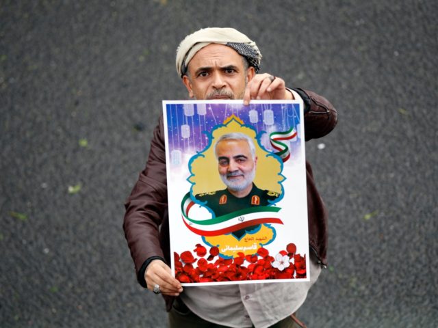 A Yemeni supporter of the Huthi movement holds a poster of slain Iranian major general Qas