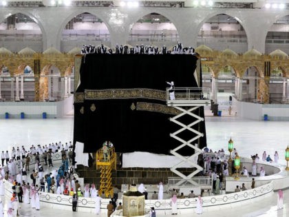 TOPSHOT - Saudi labourers put the new Kiswa, the protective cover that engulfs the Kaaba, made from black silk and gold thread and embroidered with Koran verses, on July 29, 2020 in Saudi Arabia's holy city of Mecca. - The drape which engulfs the Kaaba is formally called Kiswa and …