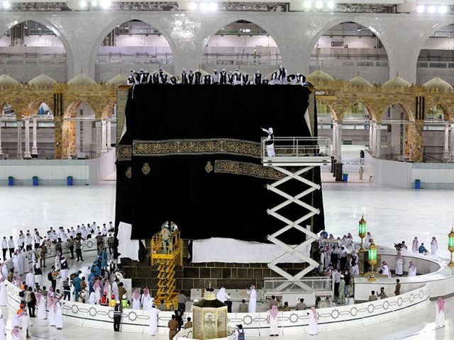 TOPSHOT - Saudi labourers put the new Kiswa, the protective cover that engulfs the Kaaba,