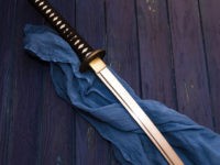 japan katana sword on the wood background with the blue shawl